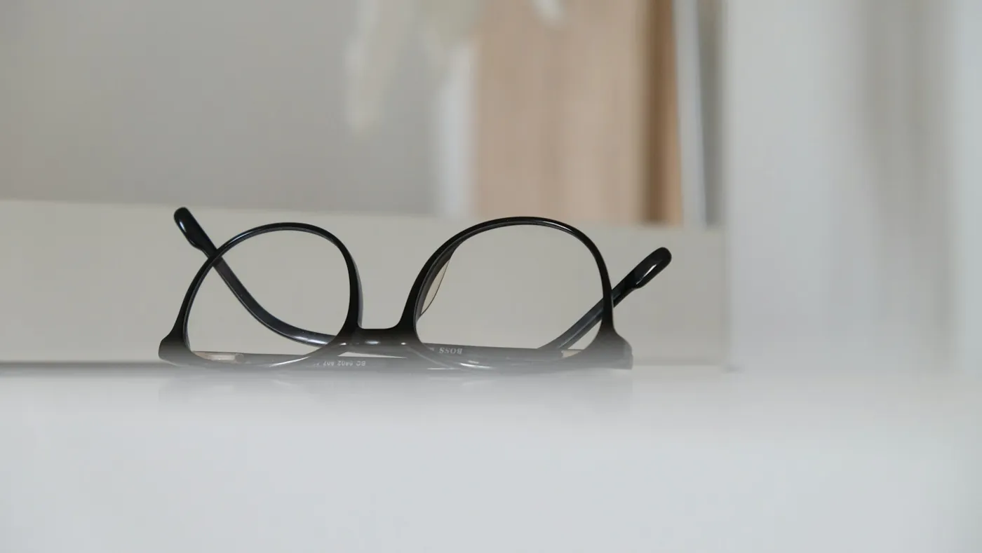 Black eyeglass frames resting on a white table