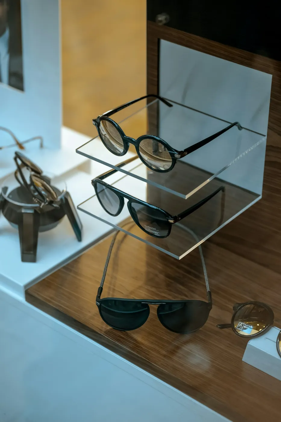 Designer sunglasses displayed on glass shelves