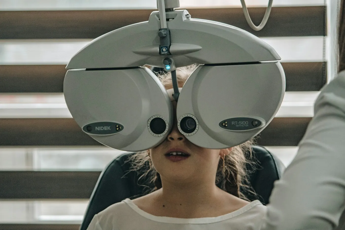 Patient looking through a phoropter during a comprehensive eye exam