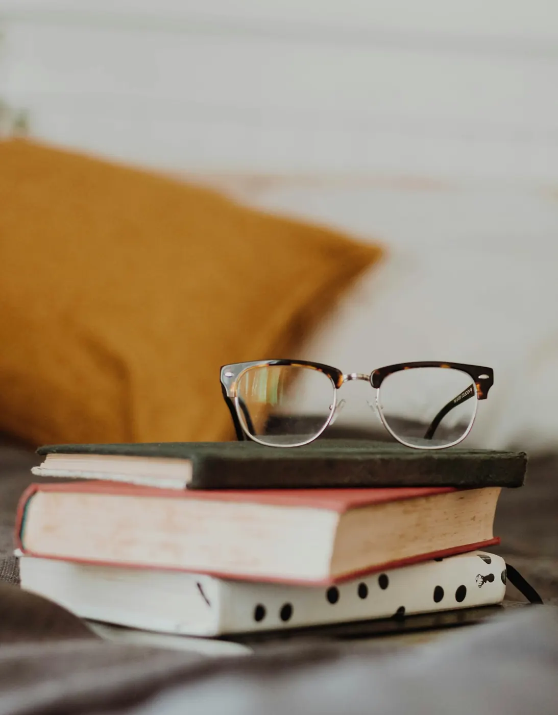 Eyeglasses resting on a stack of books